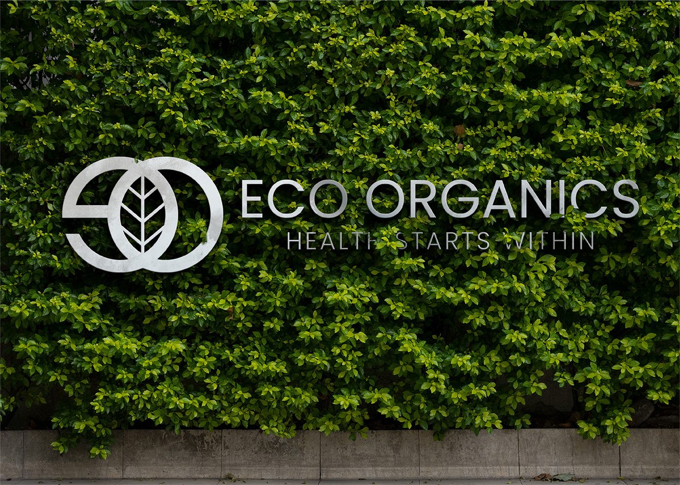 Eco Organics logo in white on a lush green living wall